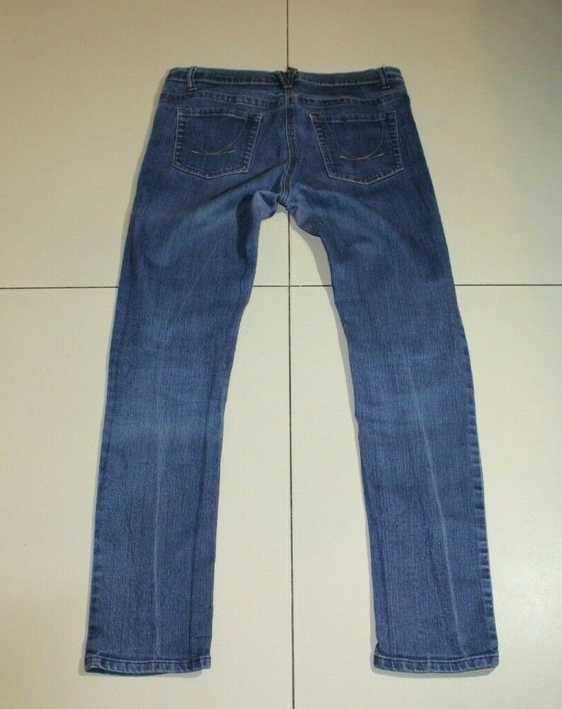 Puede incluir: Un par de pantalones vaqueros azules de mezclilla con corte recto. Los vaqueros tienen un dise&ntilde;o cl&aacute;sico de cinco bolsillos y cierre de bot&oacute;n.