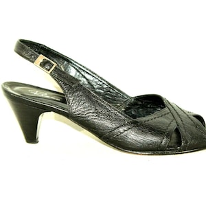 May include: Black leather heeled slingback sandals with a peep toe and a buckle fastening.