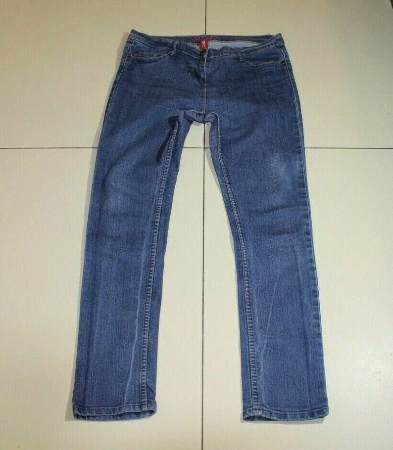 Puede incluir: Un par de pantalones vaqueros azules de pierna recta.