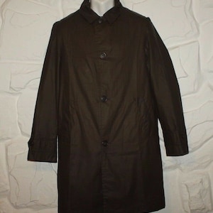 May include: A dark brown long-sleeved coat with a button-up front and a collar. The coat has two pockets on the front and a single button on each cuff.