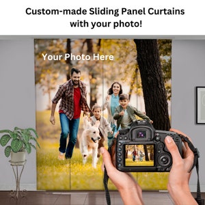 Può includere: Tende a pannello scorrevoli personalizzate con foto. Le tende mostrano una famiglia che corre in un parco, con un golden retriever. Il testo "Your Photo Here" è visibile. Una fotocamera è tenuta davanti alle tende.