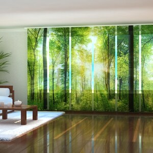Puede incluir: Una sala de estar con un sofá blanco y una mesa de café de madera. La ventana está cubierta con una cortina transparente con una imagen impresa de un bosque verde con rayos de sol que brillan a través de los árboles.