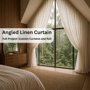Può includere: Tende in lino angolate color crema incorniciano un'ampia finestra con vista su una lussureggiante foresta verde. Il testo "Angled Linen Curtain" e "Full Project: Custom Curtains and Rail" sono visibili. Le tende sono legate.