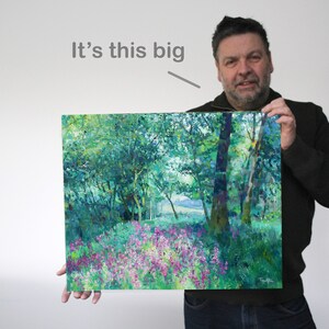K&ouml;nnte beinhalten: Ein gro&szlig;es Gem&auml;lde, das eine Waldszene mit gr&uuml;nen B&auml;umen und einem Feld mit lila Blumen zeigt. Das Gem&auml;lde wird von einer Person gehalten, und der Text "It's this big" ist &uuml;ber dem Gem&auml;lde geschrieben.