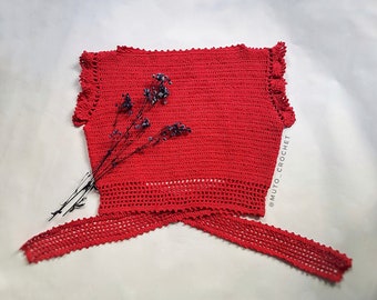 Puede incluir: Un top de ganchillo rojo vibrante con cierre de lazo. El top presenta un patrón de puntada texturizada, bordes con volantes y un diseño calado decorativo en la parte inferior. El texto "MUTO_CROCHET" es visible a la derecha.