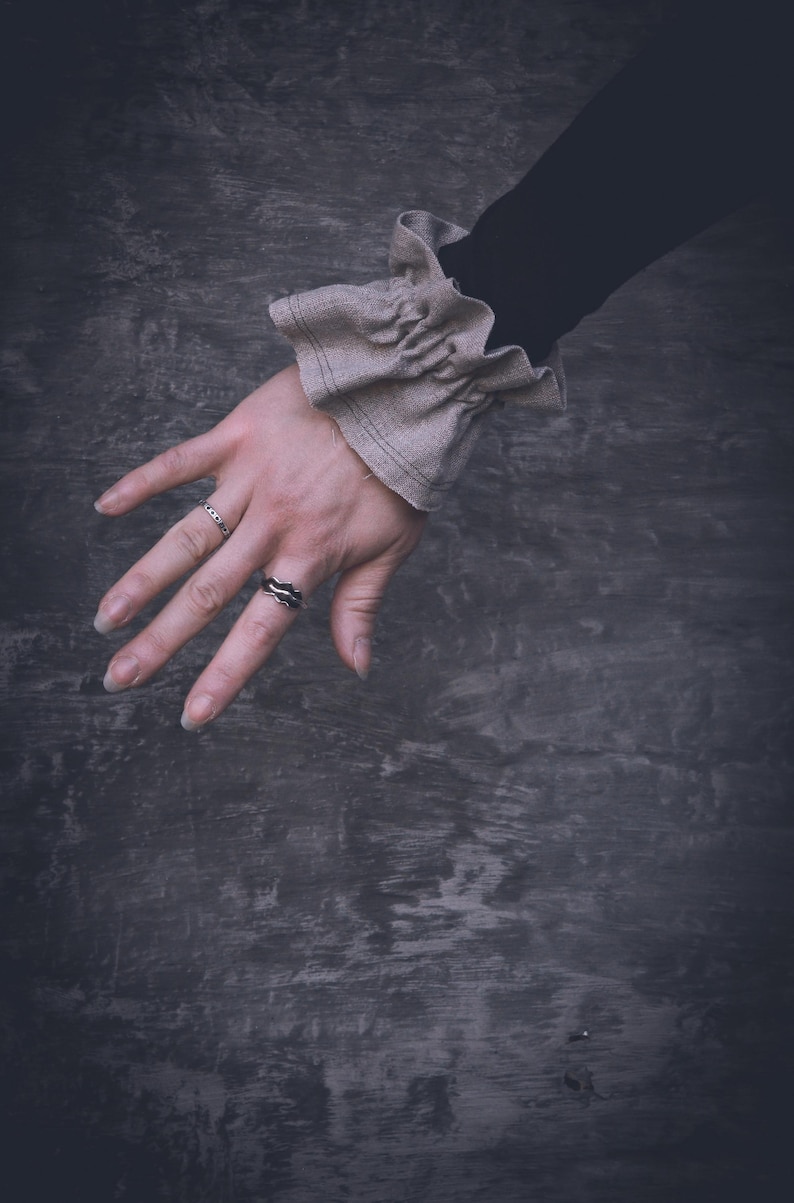 May include: A set of three ceramic mugs with a speckled, matte finish. The mugs are in cream, light grey, and dark grey. Each mug has a simple, minimalist design, ideal for coffee or tea.