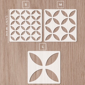 Pode incluir: Três stencils quadrados brancos com padrões geométricos, rotulados S, M e L. O stencil S mede 14,5 cm (5,71") e apresenta círculos sobrepostos. O stencil M tem um design semelhante com menos círculos. O stencil L tem um design de quatro pétalas.
