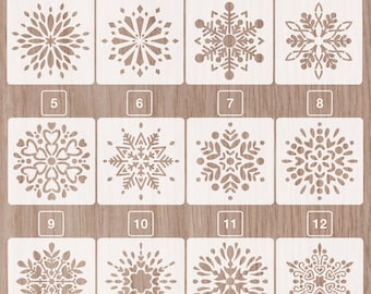 May include: Twelve different snowflake stencils, numbered 1 through 12, on a woodgrain background. The stencils are white and feature various snowflake designs.