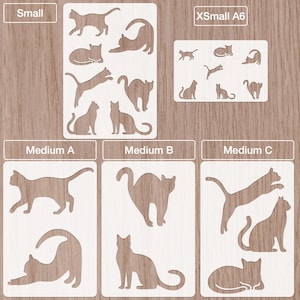 Può includere: Una collezione di stencil a forma di gatto in varie dimensioni, etichettati come "Small", "XSmall A6" e "Medium A, B, C". Gli stencil sono bianchi e presentano diverse pose di gatti, come seduti, che si allungano e saltano. Lo sfondo è in legno chiaro.