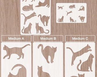 Könnte beinhalten: Eine Sammlung von Katzen-Schablonen in verschiedenen Größen, beschriftet mit "Small", "XSmall A6" und "Medium A, B, C". Die Schablonen sind weiß und zeigen verschiedene Katzenposen, wie Sitzen, Strecken und Springen. Der Hintergrund ist helles Holzmaserung.