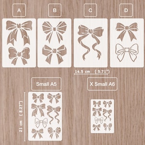 Può includere: Una collezione di stencil a forma di fiocco bianchi di vari design e dimensioni, presentati su una superficie di legno. Le misure sono indicate in centimetri e pollici. Gli stencil sono etichettati A, B, C e D, oltre alle dimensioni Small A5 e X Small A6.