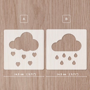 May include: Two white stencils, each measuring 14.5 cm, featuring a cloud with rain or hearts. Stencil A shows a cloud with hearts falling from it. Stencil B shows a cloud with raindrops falling from it.