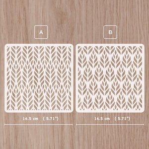 May include: Two white leaf pattern stencils, each measuring 14.5 cm (5.71") wide, are displayed on a wooden surface. The stencils are labelled A and B. The leaf design is repeated across the square stencils.