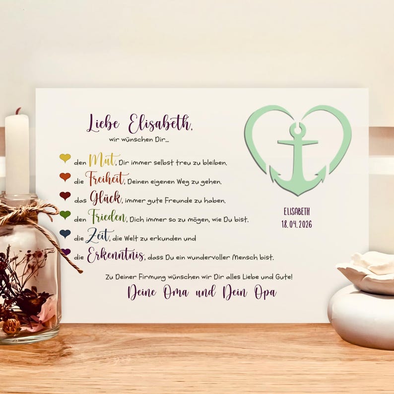 May include: A rectangular white card featuring German text, a light green anchor inside a heart shape, and the name Elisabeth with the date 18.04.2026. The card includes colorful heart icons next to lines of text, ending with a personal message.