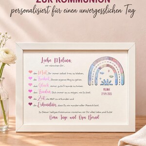 May include: A white framed print featuring the text 'Liebe Melina' and a list of wishes marked by pink hearts. The design includes a colorful rainbow illustration with the name 'MELINA' and the date '27.09.2025' printed below it in a white frame.