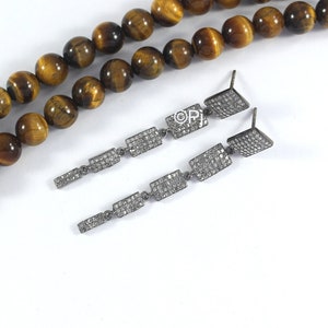 May include: A pair of long silver dangle earrings with multiple rectangular-shaped charms encrusted with small clear diamonds.