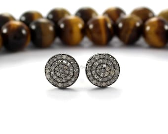 May include: A pair of silver stud earrings with a circular design featuring a cluster of small, white diamonds.