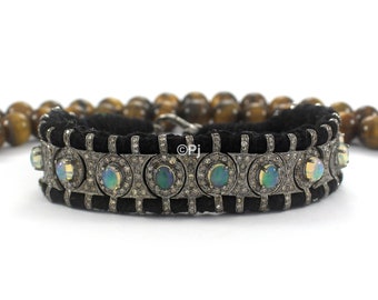 May include: A black cord bracelet with a silver chain and opal gemstones. The chain is decorated with small diamonds.