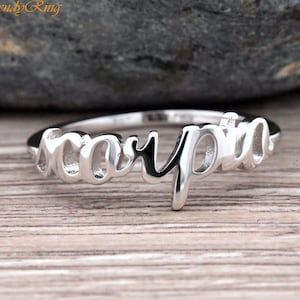 May include: Silver ring with the word "Scorpio" written in a cursive font.