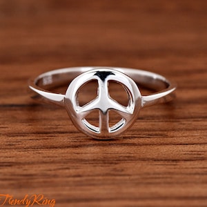 May include: A silver peace sign ring. The ring is simple and elegant, with a smooth finish.