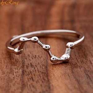 May include: A silver ring with a constellation design. The ring is made of small, round beads connected by thin lines.