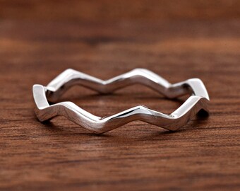 May include: A polished silver-toned ring featuring a continuous zigzag or wave pattern around the entire band. The metal surface is smooth and reflective, creating a distinct geometric shape. The text "TrendyRing" is visible in the bottom left corner.