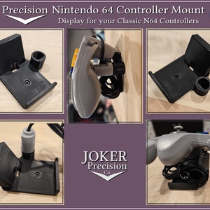 May include: A black 3D printed wall mount for displaying a Nintendo 64 controller. The mount has a slot for the controller and a small hole for the cord. The mount is made by JOKER Precision Co. and is made in the USA.