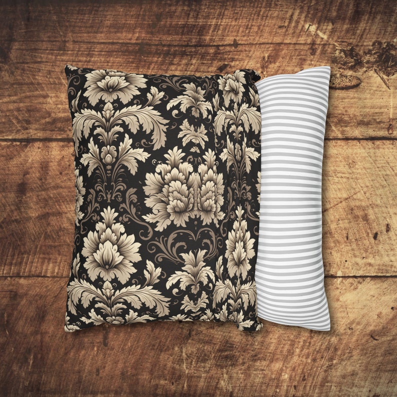 May include: Two decorative pillows, one with a black background and a beige floral pattern, and the other with a white background and gray stripes.