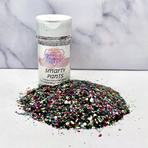 May include: A clear jar of colourful glitter labelled "Smarty Pants" Premium Polyester Glitter DiamondDustShop Etsy. The glitter is a mix of green, blue, pink, and black.