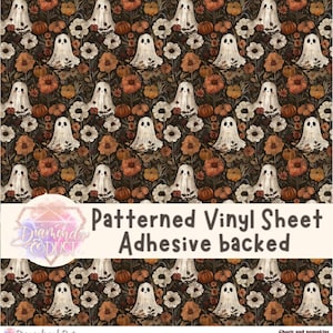 Puede incluir: Lámina de vinilo adhesiva estampada con un diseño repetido de fantasmas blancos, calabazas y flores en tonos marrones, naranjas y crema. El texto "Patterned Vinyl Sheet Adhesive backed" está en la imagen. Ideal para manualidades de Halloween.