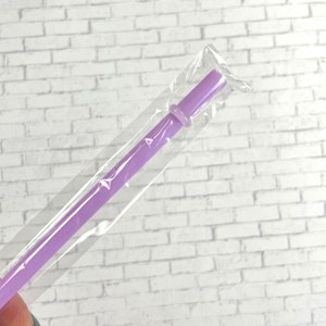 May include: A single purple plastic drinking straw in a clear plastic bag.