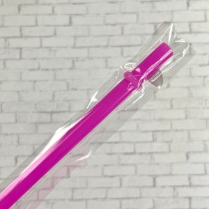 K&ouml;nnte beinhalten: Ein einzelner wiederverwendbarer Trinkhalm in Pink, verpackt in durchsichtigem Plastik.