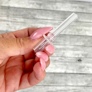 May include: A clear plastic smoking pipe with a removable mouthpiece. The pipe is designed with multiple holes for airflow.