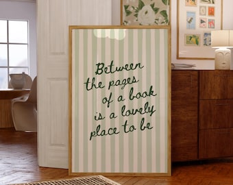 Może przedstawiać: Oprawiony wydruk z jasnozielonym i białym paskowanym tłem oraz tekstem "Between the pages of a book is a lovely place to be" w ciemnozielonym skrypcie. Widoczne są inne oprawione dzieła sztuki i meble.