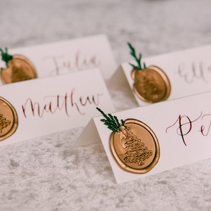 Tarjetas de lugar con caligrafía navideña de pino y sello de cera