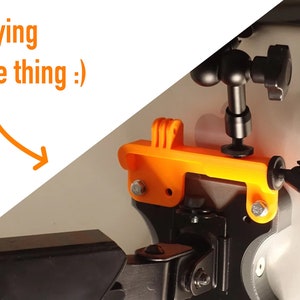 May include: Orange 3D printed GoPro mount with a black adjustable arm and a black ball head. The mount is attached to a black tripod.