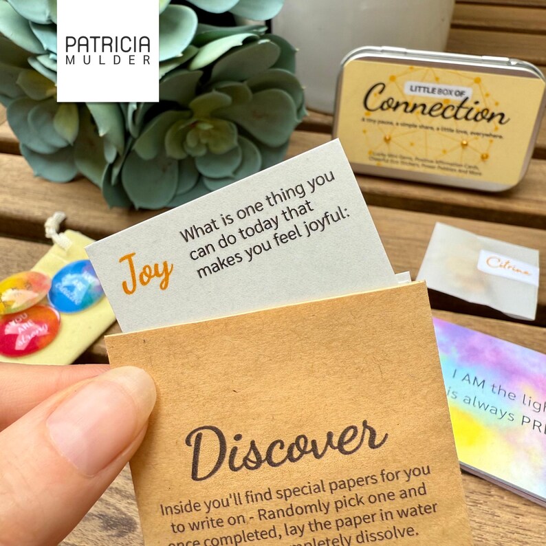 Little box of connection made to inspire and bring people together. Includes discovery papers that ask meaningful prompts and power glass pebbles with you are kind, you are strong and other versions. Also 9 affirmation cards, and a small glassine envelope with 6 little gemstones. There’s also a paper pouch with 3 eco friendly stickers in this box. You can pick a blue, yellow or green front and citrine, amethyst or rose quartz gems. Share with friends, lift spirits and gift the gift of connection