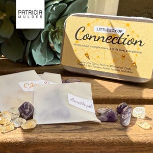 Little box of connection made to inspire and bring people together. Includes discovery papers that ask meaningful prompts and power glass pebbles with you are kind, you are strong and other versions. Also 9 affirmation cards, and a small glassine envelope with 6 little gemstones. There’s also a paper pouch with 3 eco friendly stickers in this box. You can pick a blue, yellow or green front and citrine, amethyst or rose quartz gems. Share with friends, lift spirits and gift the gift of connection