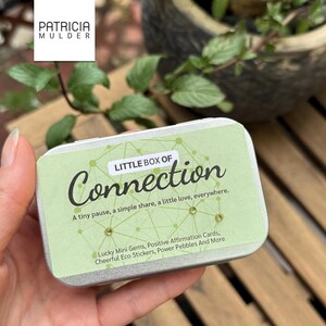 Little box of connection made to inspire and bring people together. Includes discovery papers that ask meaningful prompts and power glass pebbles with you are kind, you are strong and other versions. Also 9 affirmation cards, and a small glassine envelope with 6 little gemstones. There’s also a paper pouch with 3 eco friendly stickers in this box. You can pick a blue, yellow or green front and citrine, amethyst or rose quartz gems. Share with friends, lift spirits and gift the gift of connection