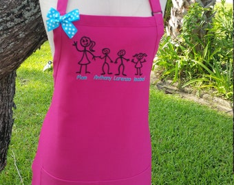 Puede incluir: Un delantal fucsia con un diseño de figuras de palitos de familia y los nombres Mom, Anthony, Lorenzo e Isabel. El delantal tiene un lazo azul de lunares y un bolsillo. El delantal se muestra en un maniquí.