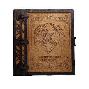 May include: Wooden box with a dragon engraving. The box is made of dark brown and light brown wood. The dragon is centered on the front, above the text "Where Stories Are Woven". The box has decorative hinges and clasps.