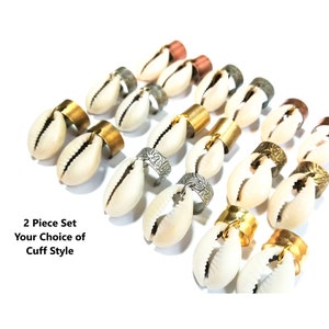 May include: A set of two shell rings with different metal cuff styles. The rings are made of cowrie shells and feature gold, silver, and copper metal cuffs. The text "2 Piece Set Your Choice of Cuff Style" is visible in the image.