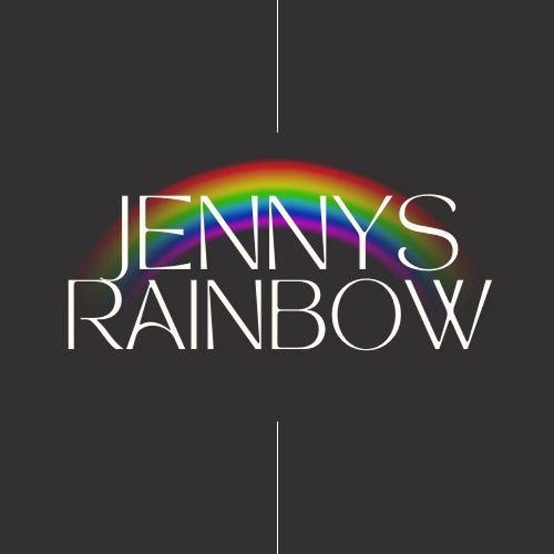 May include: A graphic design featuring the white text JENNY'S RAINBOW centered on a dark gray background. A vibrant, multi-colored rainbow arc is positioned behind the text, with thin white vertical lines extending above and below the design.