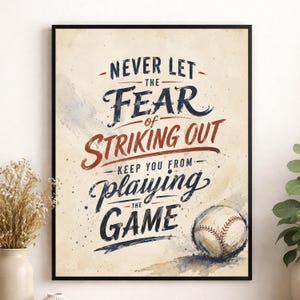 May include: A framed wall art print featuring a baseball theme with the text NEVER LET THE FEAR OF STRIKING OUT KEEP YOU FROM PLAYING THE GAME in dark blue and red ink on a cream background, accompanied by a detailed illustration of a baseball.