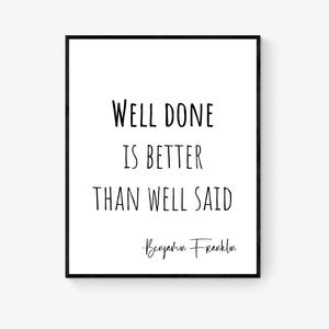 May include: A framed print featuring the quote "Well Done Is Better Than Well Said" by Benjamin Franklin in black text on a white background. The print is in a black frame.