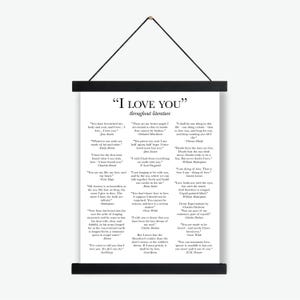 May include: A white vertical wall hanging poster featuring the title I LOVE YOU throughout literature in black text. The poster displays various literary quotes about love from authors like Jane Austen and William Shakespeare, held by black wooden rails.