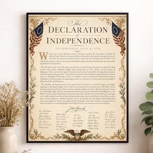 May include: A framed print of the Declaration of Independence with a parchment-style background, black text, and ornate gold borders. Two American flags flank the top corners, and a bald eagle emblem is centered at the bottom of the document.