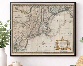 May include: A framed antique-style map of New Jersey, Pennsylvania, New York, and New England. The map features beige parchment tones, black text, and a decorative cartouche in the lower right corner with the title and cartographic details.