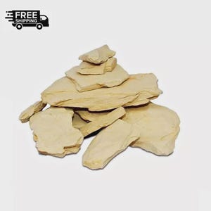 May include: A pile of light tan, irregularly shaped clay pieces. The pieces vary in size and thickness, with a rough, natural texture. The image includes a black and white graphic of a truck with the words "FREE SHIPPING".