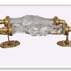 May include: A pair of clear glass door pulls with faceted edges and gold metal mounting plates.